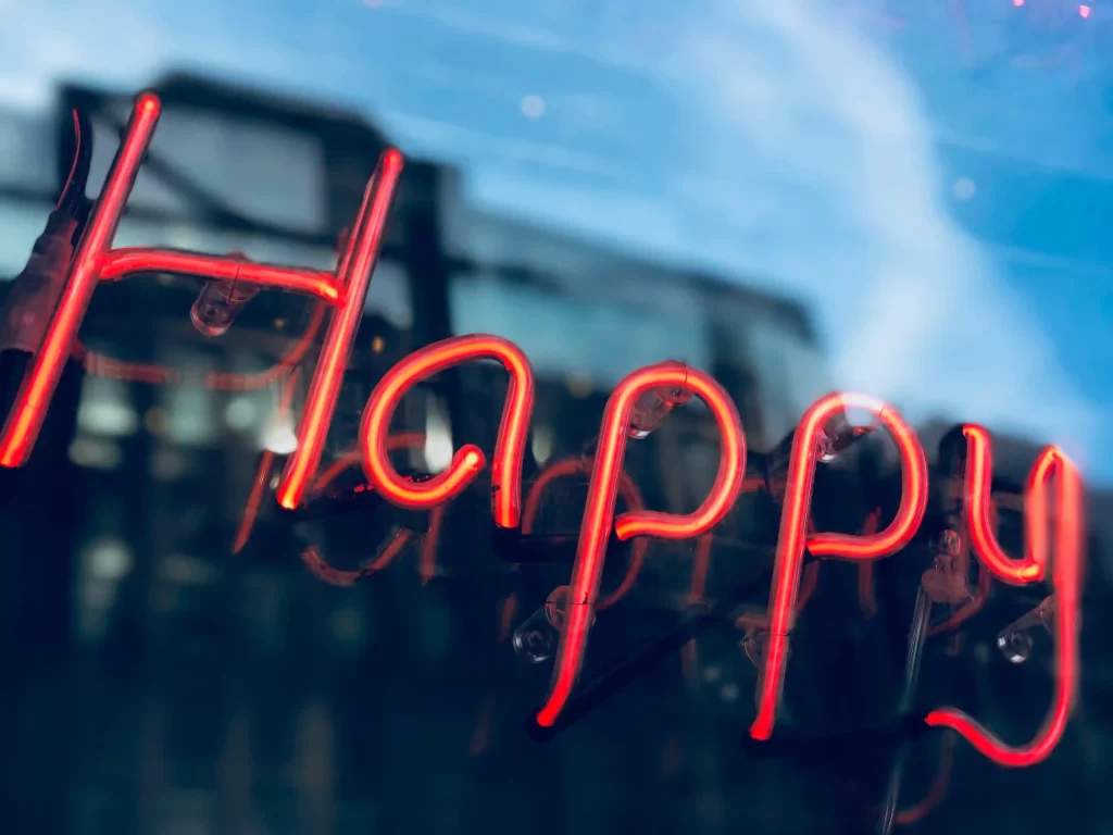 Neon sign displaying 'Happy' for a happiness improvement article