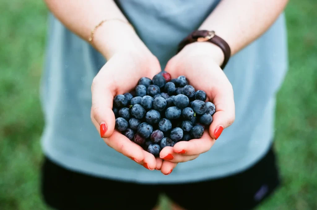 Woman with blueberries - symbolizing gut-mental health connection
