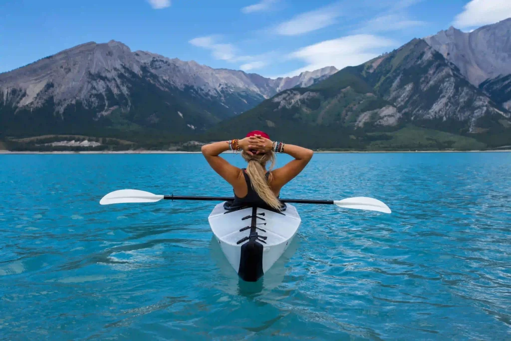 Woman kayaking in ocean, depicting nature's mental health benefits.